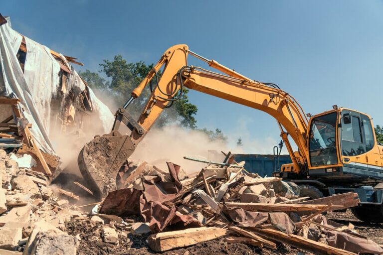 Destruction of old house by excavator with lot of dust.